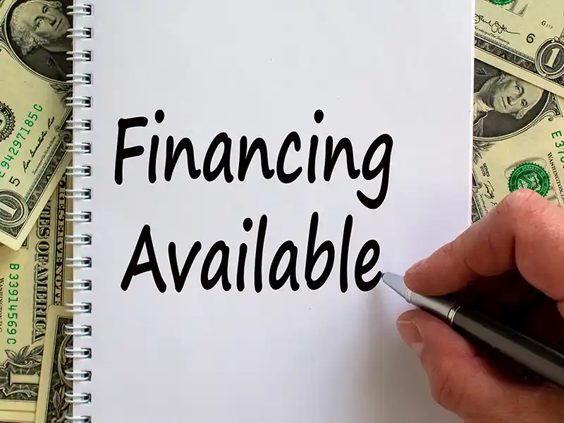 'Financing Available' being written on a notepad